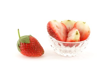 Strawberries in glass dish over white background