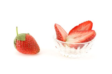 Strawberries in glass dish over white background