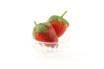 Two strawberries in a glass dish