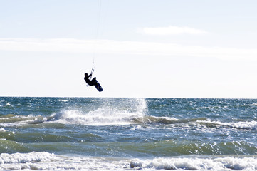 Silhouette of a kite-surfer jumping