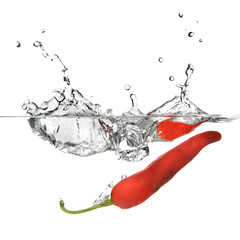 red pepper dropped into water with splash isolated on white