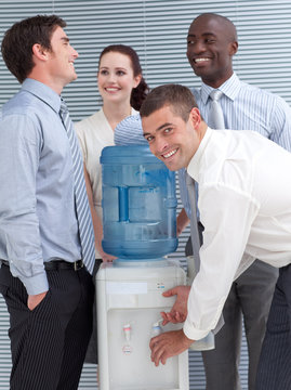 Businesspeople standing around water cooler