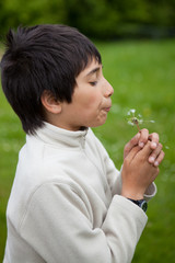 boy blowing dandelion seeds