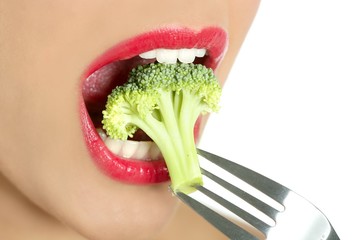 Fototapeta premium Broccoli on steel fork in woman mouth