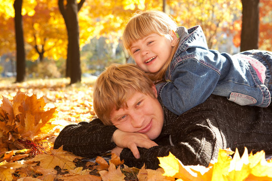 Daddy and doughter on autumn leaves