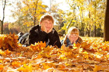 Daddy and daughter on autumn leaves