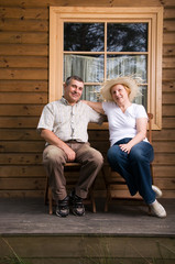 Obraz premium Senior couple having a rest on a terrace in front of house