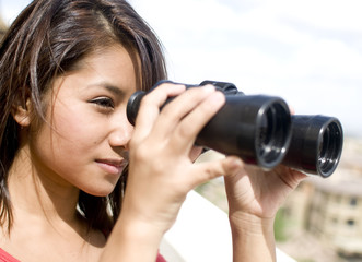 Young woman looking through binoculars