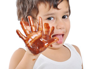 Little cute kid with chocolate on face and hands