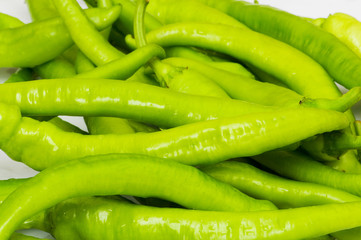 Green peppers in the plate isolated on white