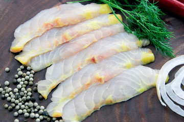 Fresh sturgeon fillet slices decorated on brown cutting board