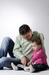 man and child reading a book