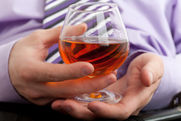 Hand with glass of cognac