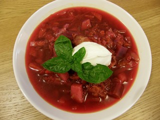 Bowl of borsch (Russian beetroot soup) with sour cream and basil
