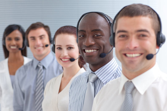 Afro-American businessman smiling and standing in a call center