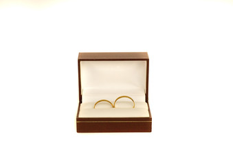 Two golden wedding rings in a box isolated on white