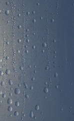 Water`s drop on the blue surface.