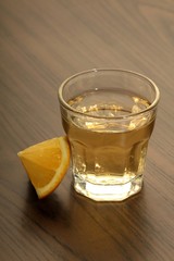 Tequila shot with lemon on a wooden table