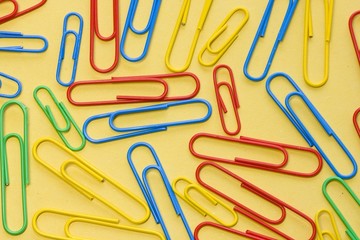 Paper clips on a yellow background.