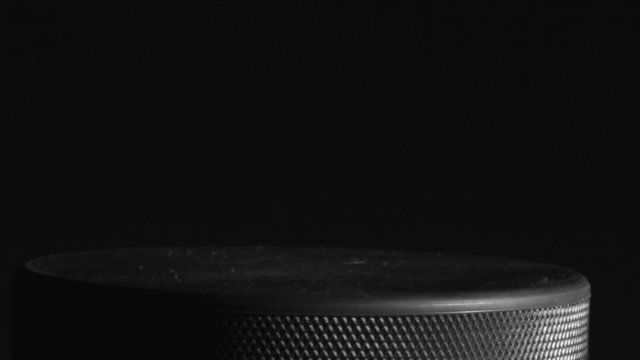 Hockey puck against black background loop - HD