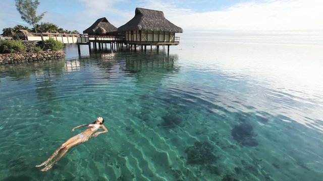 Young woman swimming in a coral lagoon