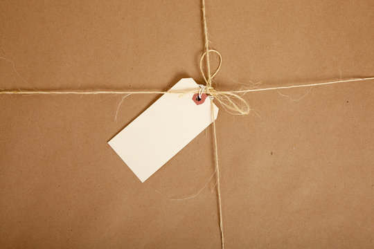 A box wrapped in brown paper with blank tag