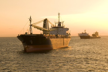 Fototapeta premium Colorful sky and dramatic sun with a ship silhouette on horizon