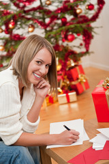Obraz na płótnie Canvas Attractive blond woman writing Christmas cards