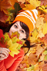 Naklejka na ściany i meble Girl in autumn orange hat on leaf group.Outdoor.