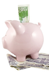 piggy bank with fifty and twenty pound notes on white