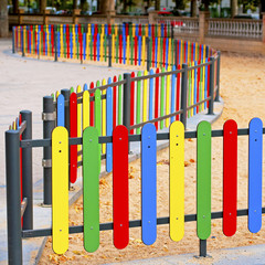 Colourful rows of painted wood on a playground fence