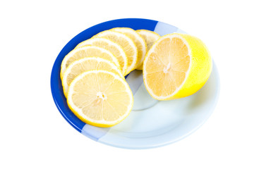 Ripe yellow lemon on dark blue saucer