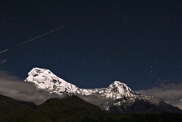 Shooting star over the snow mountain