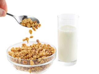 Drops flakes in bowl with glass of milk. Isolated