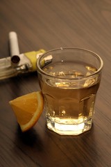 Tequila shot with lemon on a wooden table
