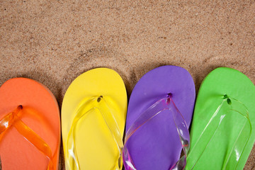 Multicolored flipflops in the sand