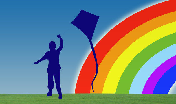 child silhouette plays with kite against background rainbow