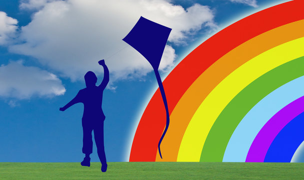 child silhouette plays with kite against background rainbow