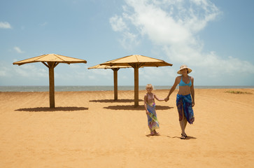 Mother and daughter walking along the beach