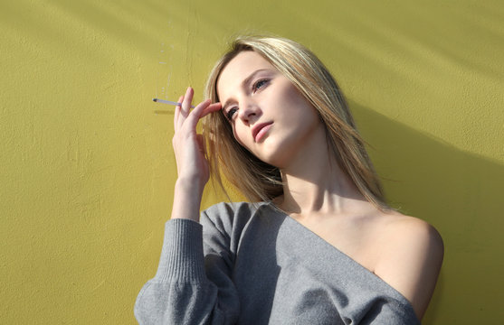 pretti , young cowgirl smoke on yellow wall
