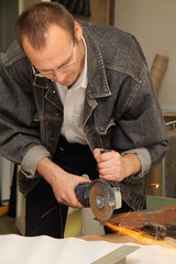man works with a circulation saw in studio