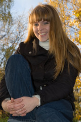 Obraz premium Smiling young girl in yellow autumn park