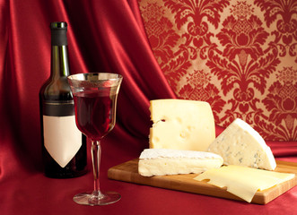 Red wine and cheese varieties on a cheeseboard.