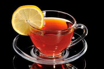 Cup of tea with segment of lemon on a black background