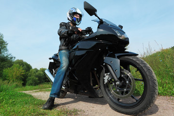 Obraz na płótnie Canvas motorcyclist standing on country road, bottom view