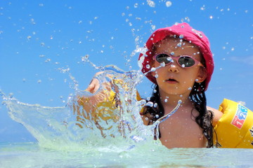 Obraz na płótnie Canvas Fillette jouant dans l'eau azur d'un lagon.