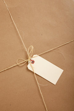 A box wrapped in brown paper with blank tag