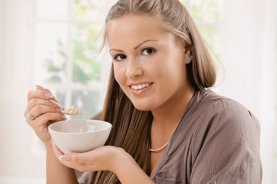 Young woman eating ceral