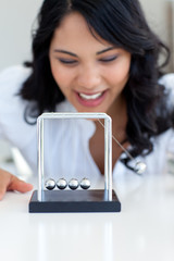 Businesswoman having fun with Newton balls