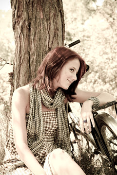 Beautiful girl sitting near bike Photo in retro style.